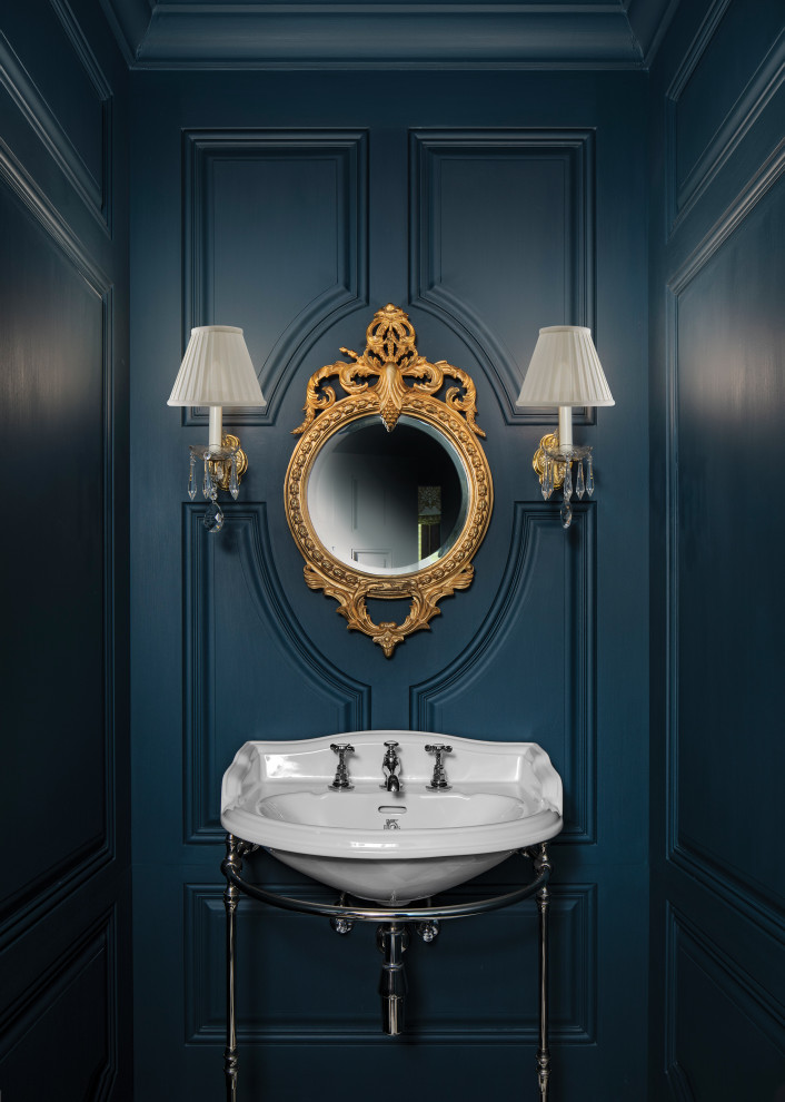 This is an example of a traditional powder room with blue walls, marble floors and a pedestal sink.