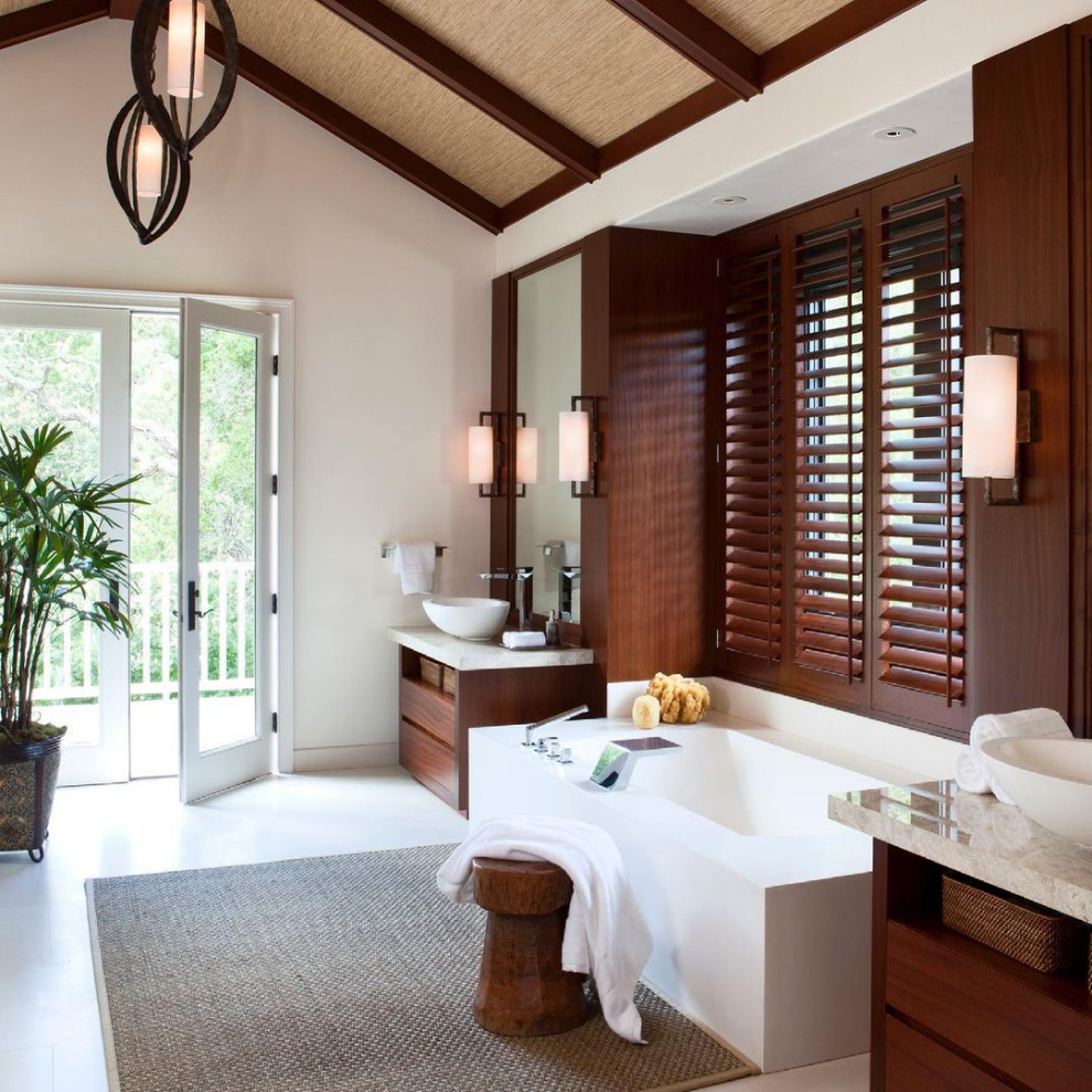 Idéer för att renovera ett tropiskt beige beige badrum, med luckor med infälld panel, skåp i mellenmörkt trä, ett badkar i en alkov, vita väggar och ett fristående handfat