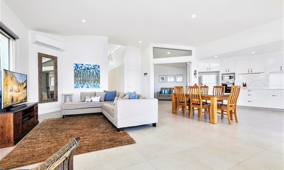 Large beach style open concept living room in Sunshine Coast with white walls, ceramic floors, a freestanding tv and beige floor.