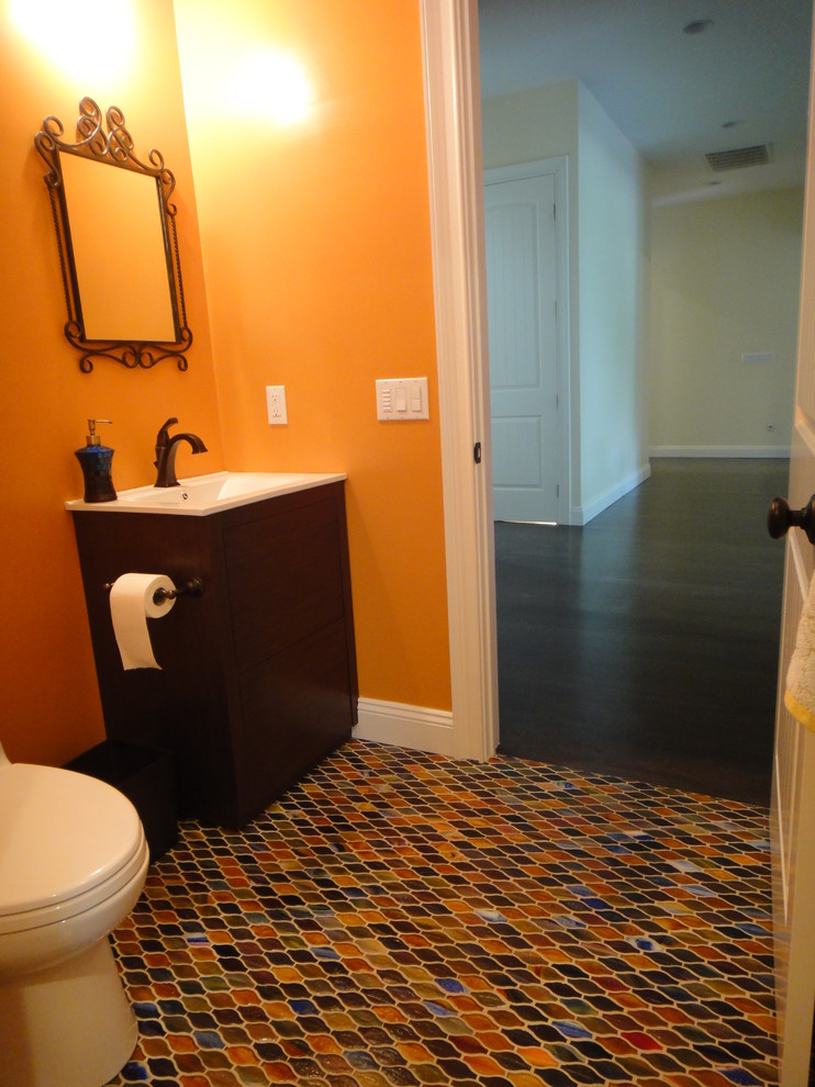 Small eclectic 3/4 bathroom in New York with an integrated sink, flat-panel cabinets, dark wood cabinets, engineered quartz benchtops, a one-piece toilet, multi-coloured tile, orange walls and porcelain floors.