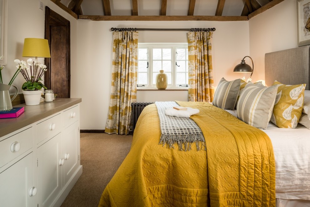 Photo of a mid-sized country guest bedroom in Sussex with white walls, carpet and beige floor.
