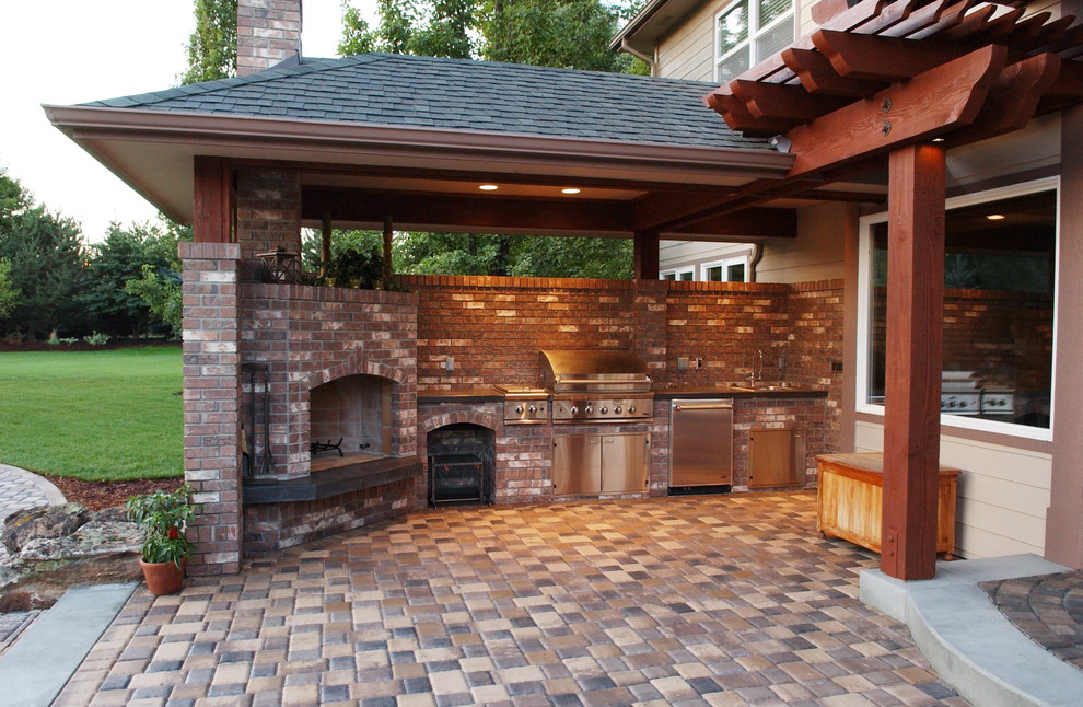 This is an example of a mid-sized traditional backyard patio in Boise with an outdoor kitchen, concrete pavers and a roof extension.