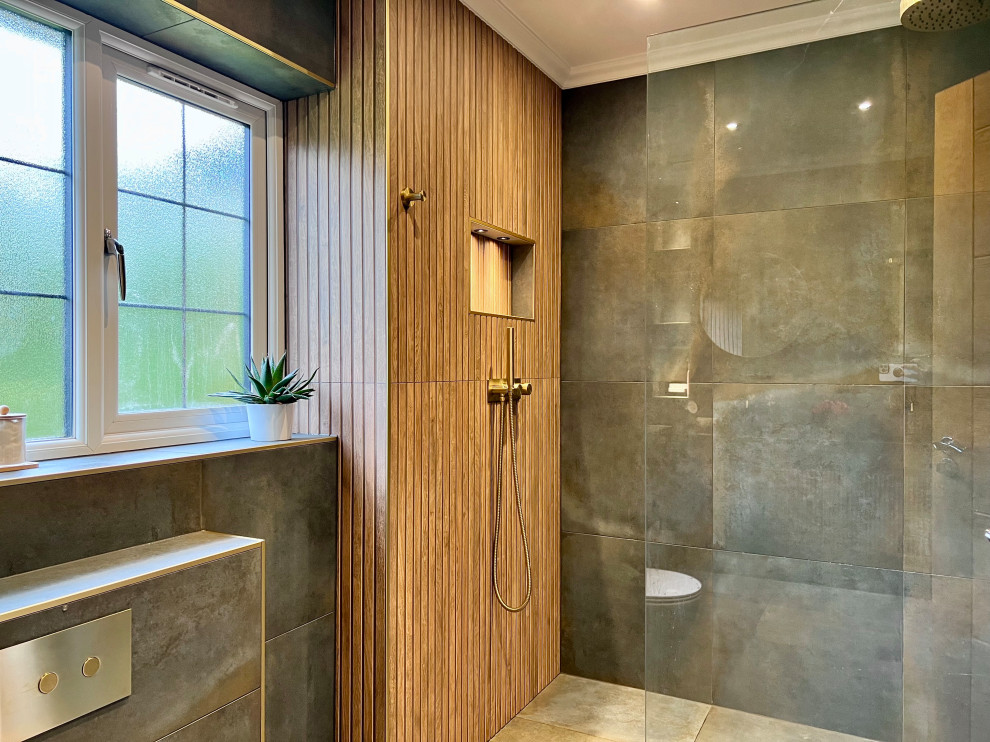 Inspiration for a large bohemian ensuite bathroom in London with louvered cabinets, medium wood cabinets, a walk-in shower, a wall mounted toilet, green tiles, green walls, porcelain flooring, a console sink, tiled worktops, green floors, an open shower, black worktops, a feature wall and a floating vanity unit.