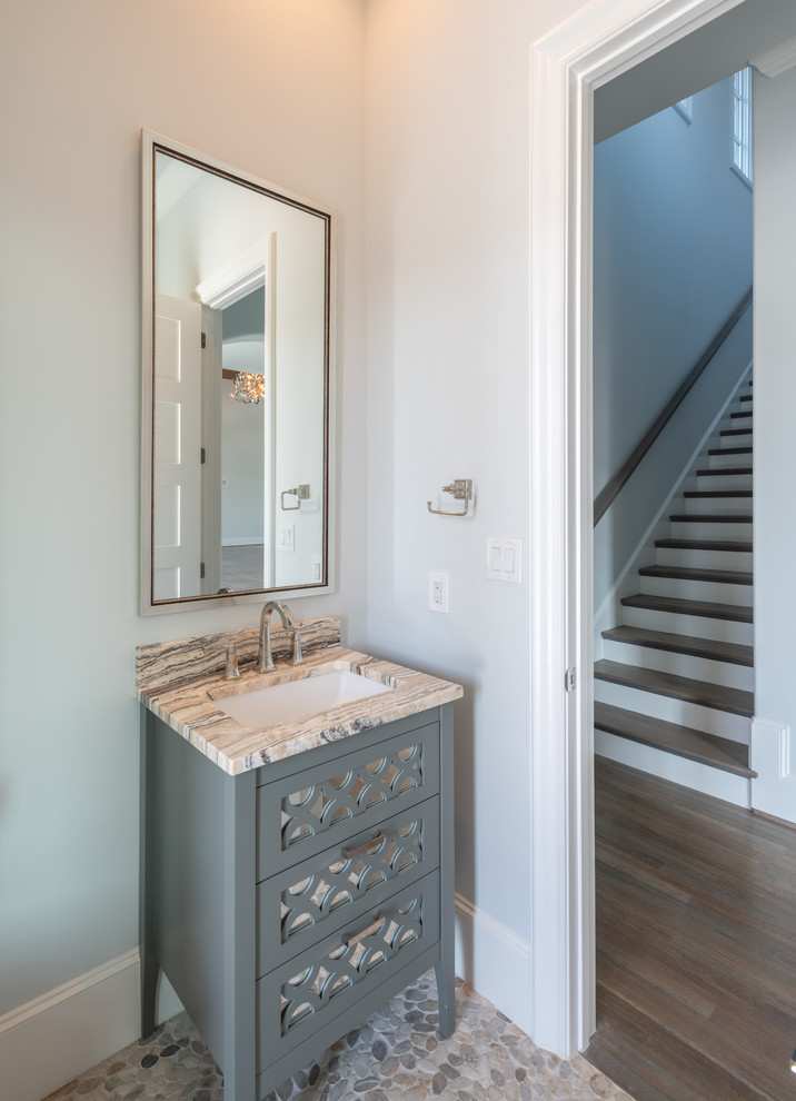 Small transitional powder room in Dallas with furniture-like cabinets, blue cabinets, grey walls, porcelain floors, an undermount sink, limestone benchtops, grey floor and grey benchtops.
