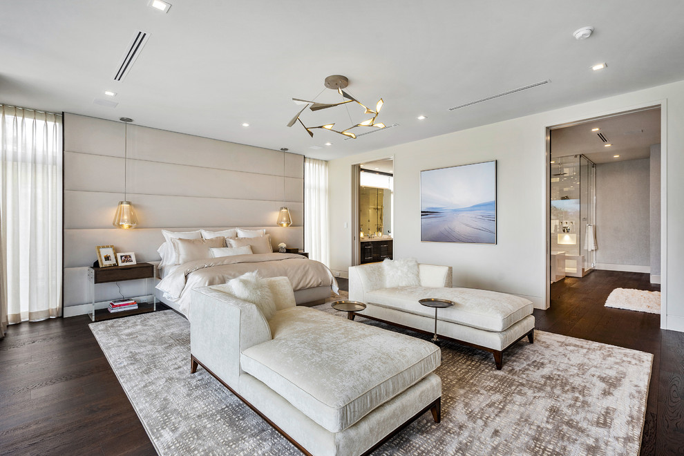 Large contemporary master bedroom in Miami with beige walls, brown floor and dark hardwood floors.