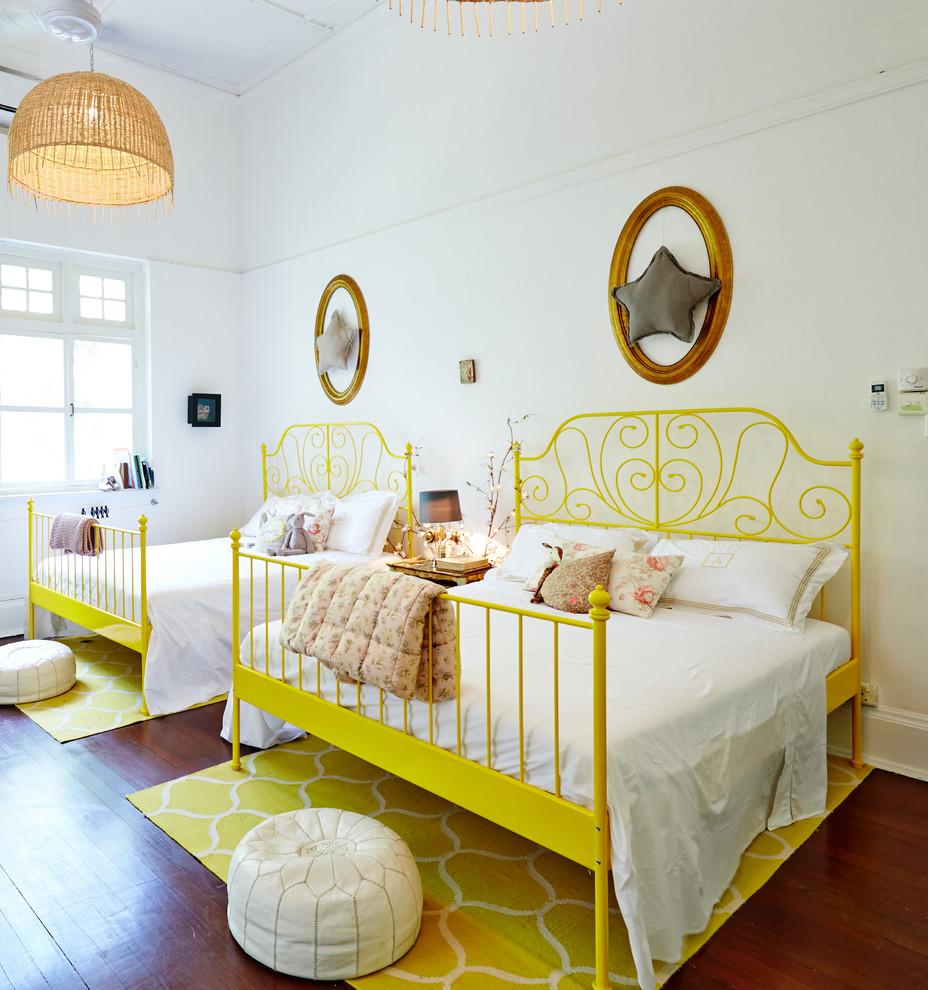 Photo of a tropical kids' room with white walls, medium hardwood floors and brown floor.