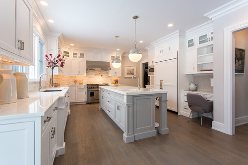 Transitional kitchen with two-tone premade kitchen cabinet, bright backsplash, and modern lighting