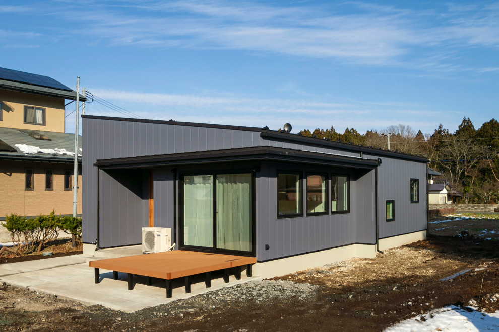 На фото: одноэтажный, серый частный загородный дом среднего размера в современном стиле с облицовкой из металла, односкатной крышей, металлической крышей и серой крышей
