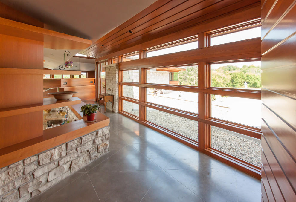 Пример оригинального дизайна: большой коридор в стиле ретро с бетонным полом, деревянным потолком и деревянными стенами