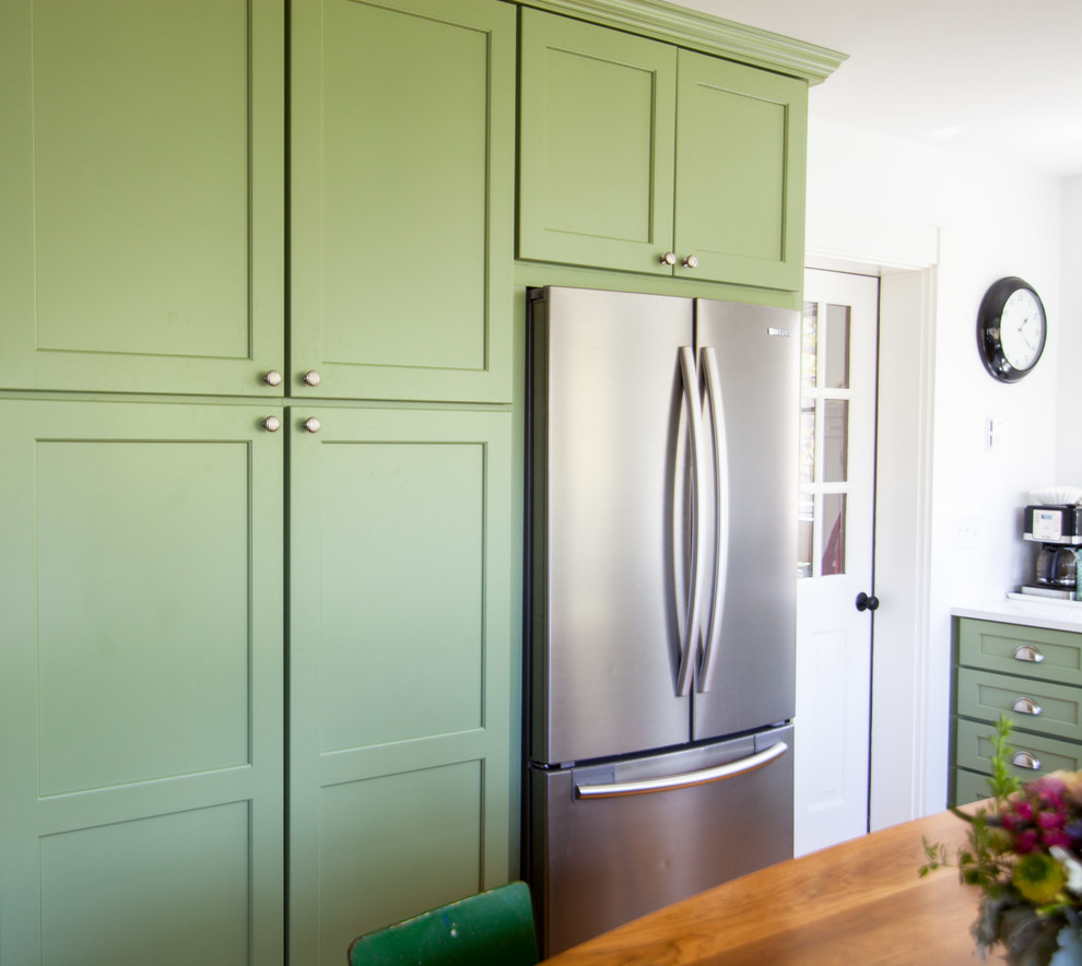 This is an example of a mid-sized u-shaped open plan kitchen in Boston with an undermount sink, shaker cabinets, green cabinets, quartz benchtops, white splashback, stainless steel appliances and with island.
