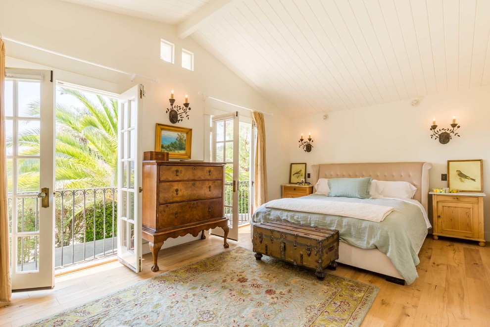 This is an example of a mid-sized country master bedroom in Santa Barbara with white walls and light hardwood floors.