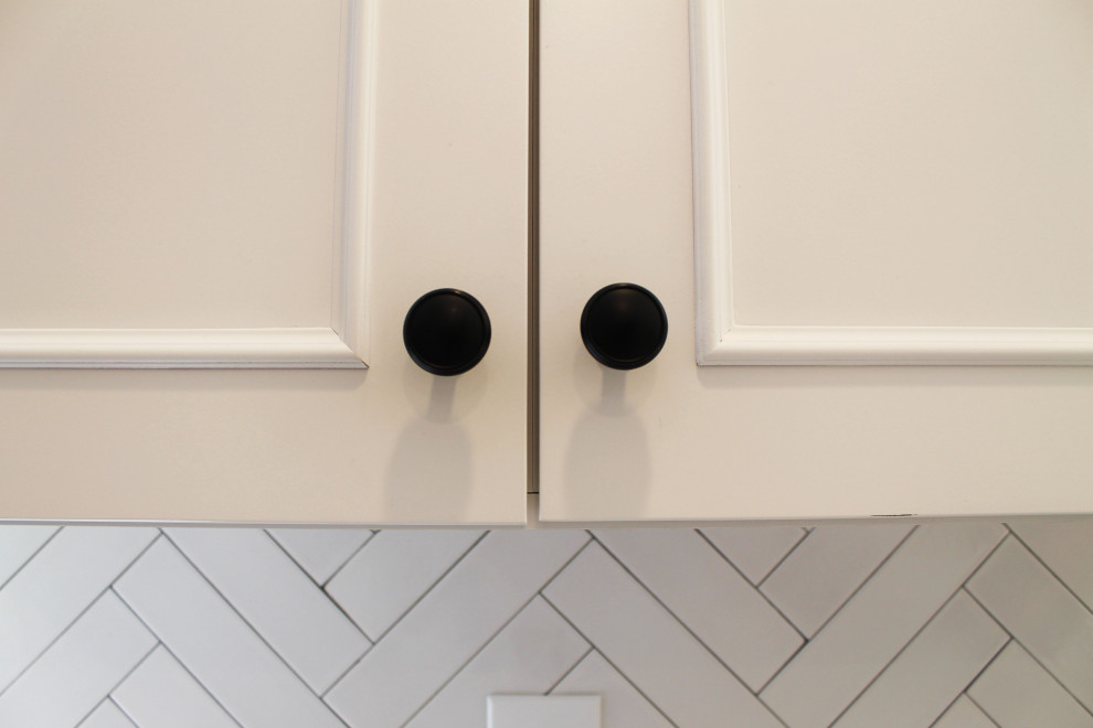 Eat-in kitchen - mid-sized transitional u-shaped medium tone wood floor eat-in kitchen idea in Seattle with an undermount sink, shaker cabinets, white cabinets, quartz countertops, white backsplash, ceramic backsplash, stainless steel appliances, a peninsula and gray countertops