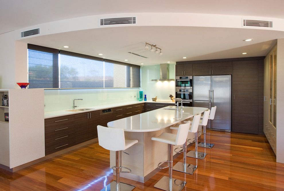 Design ideas for a contemporary u-shaped kitchen in Perth with an undermount sink, flat-panel cabinets, dark wood cabinets, glass sheet splashback and stainless steel appliances.