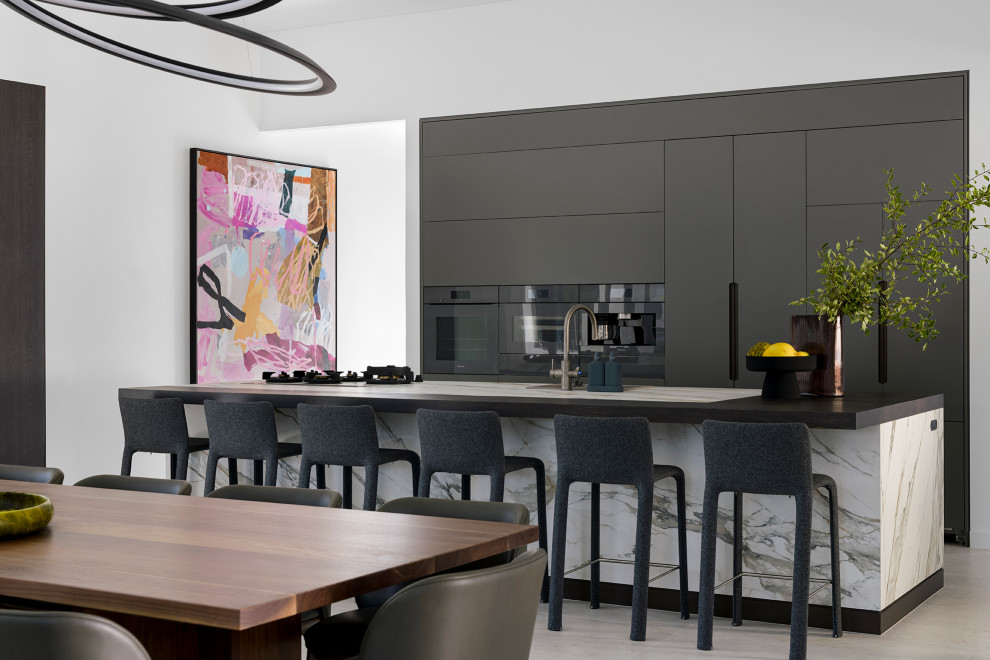 Design ideas for a contemporary galley eat-in kitchen in Brisbane with flat-panel cabinets, grey cabinets, black appliances, with island, grey floor and grey benchtop.