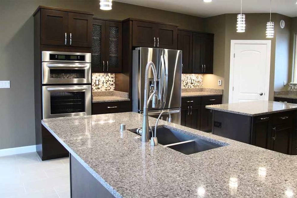 Inspiration for a large transitional u-shaped porcelain tile eat-in kitchen remodel with an undermount sink, shaker cabinets, dark wood cabinets, quartz countertops, multicolored backsplash, glass tile backsplash, stainless steel appliances and two islands