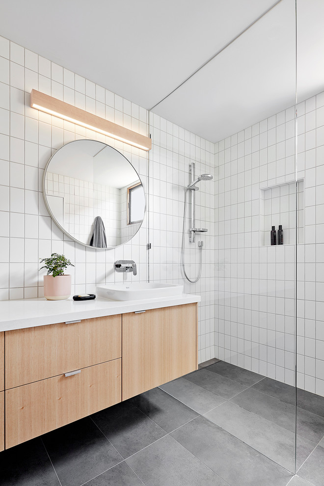 Inspiration for a beach style bathroom in Melbourne with flat-panel cabinets, light wood cabinets, a curbless shower, white tile, a drop-in sink, grey floor and an open shower.