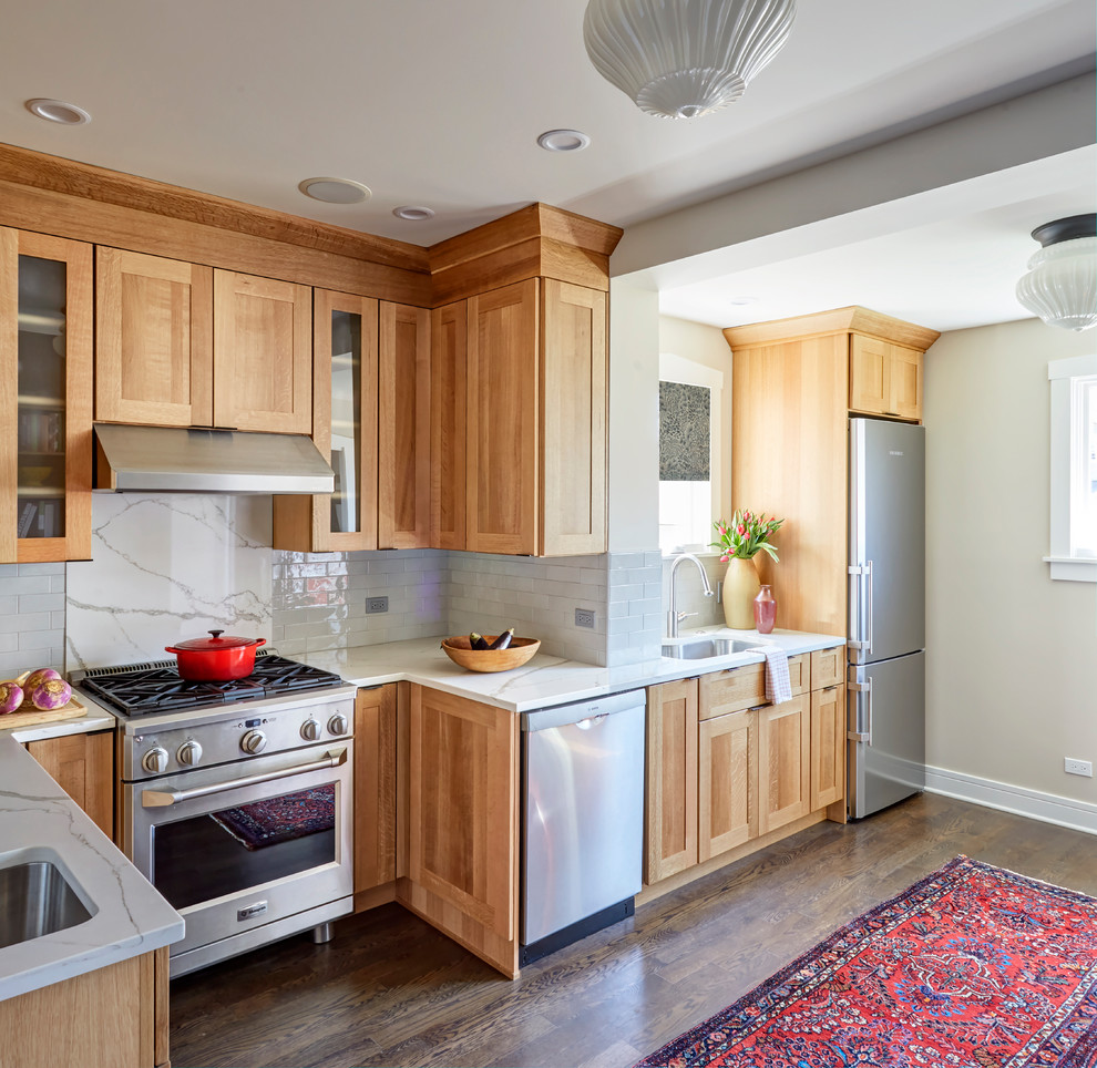 Mid-sized arts and crafts galley eat-in kitchen in Chicago with a single-bowl sink, shaker cabinets, light wood cabinets, quartz benchtops, grey splashback, subway tile splashback, stainless steel appliances, dark hardwood floors, a peninsula and brown floor.
