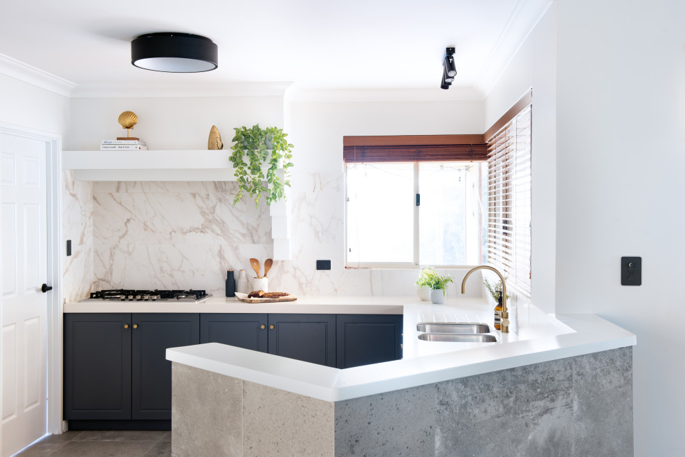 Inspiration for a mid-sized transitional u-shaped kitchen in Perth with an undermount sink, raised-panel cabinets, blue cabinets, beige splashback, a peninsula, grey floor and white benchtop.
