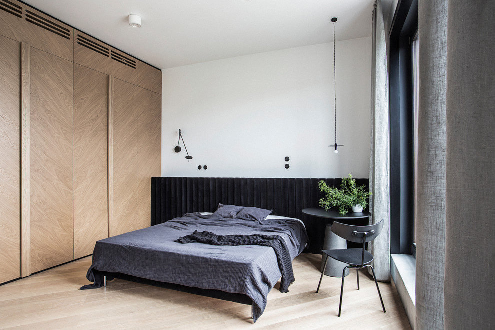 Photo of a contemporary bedroom in Berlin with white walls, light hardwood floors and beige floor.