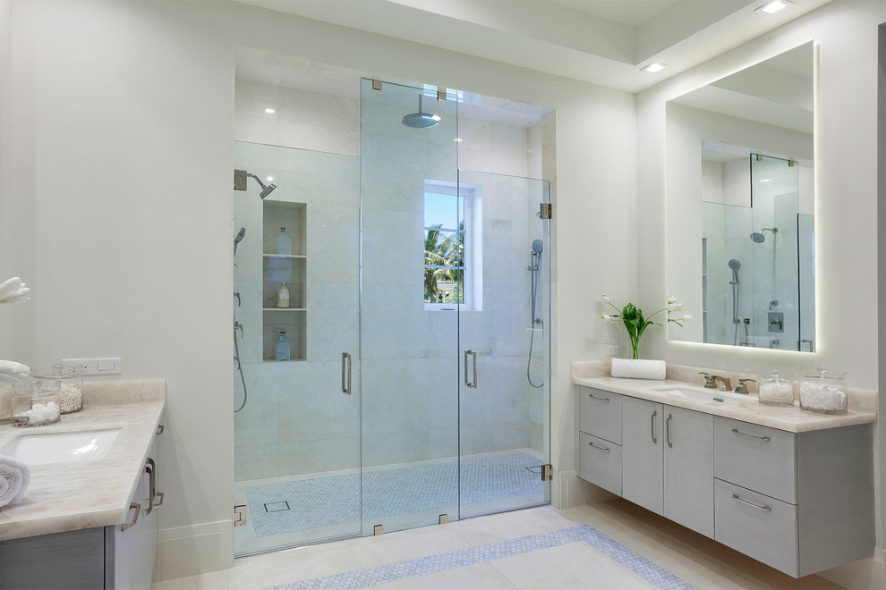 Inspiration for a large contemporary master bathroom in Miami with beige tile, beige floor, a hinged shower door, beige benchtops, grey cabinets, a curbless shower, white walls, flat-panel cabinets, a one-piece toilet, porcelain tile, ceramic floors, an undermount sink and marble benchtops.