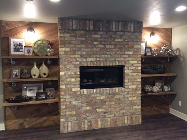 Inspiration for a rustic basement remodel with a standard fireplace and a brick fireplace