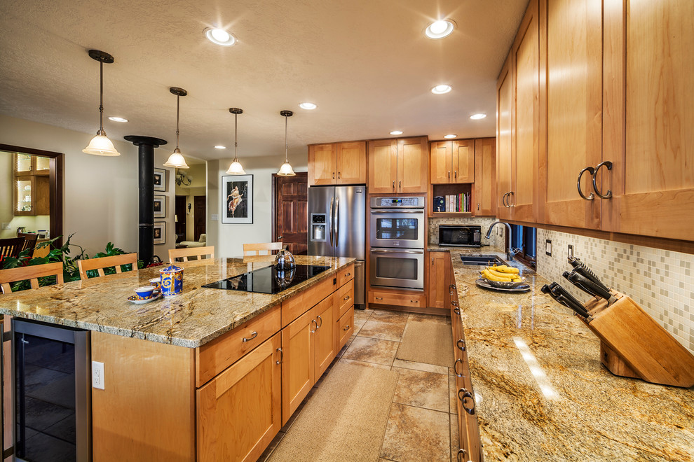 This is an example of a large contemporary u-shaped kitchen in Albuquerque with an undermount sink, shaker cabinets, light wood cabinets, granite benchtops, grey splashback, mosaic tile splashback, stainless steel appliances and ceramic floors.