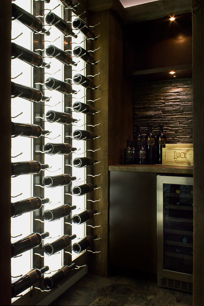 Photo of a small contemporary wine cellar in Vancouver with cork floors and display racks.