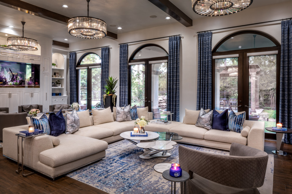 Expansive classic open plan games room in Houston with grey walls, medium hardwood flooring, a hanging fireplace, a metal fireplace surround, a wall mounted tv, brown floors and wallpapered walls.