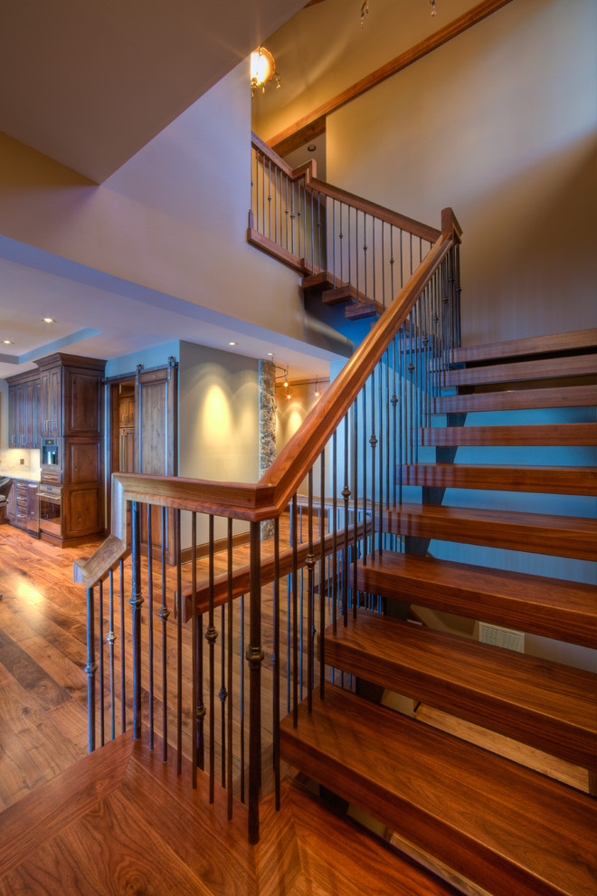 Large transitional wood u-shaped staircase in Other with open risers and metal railing.