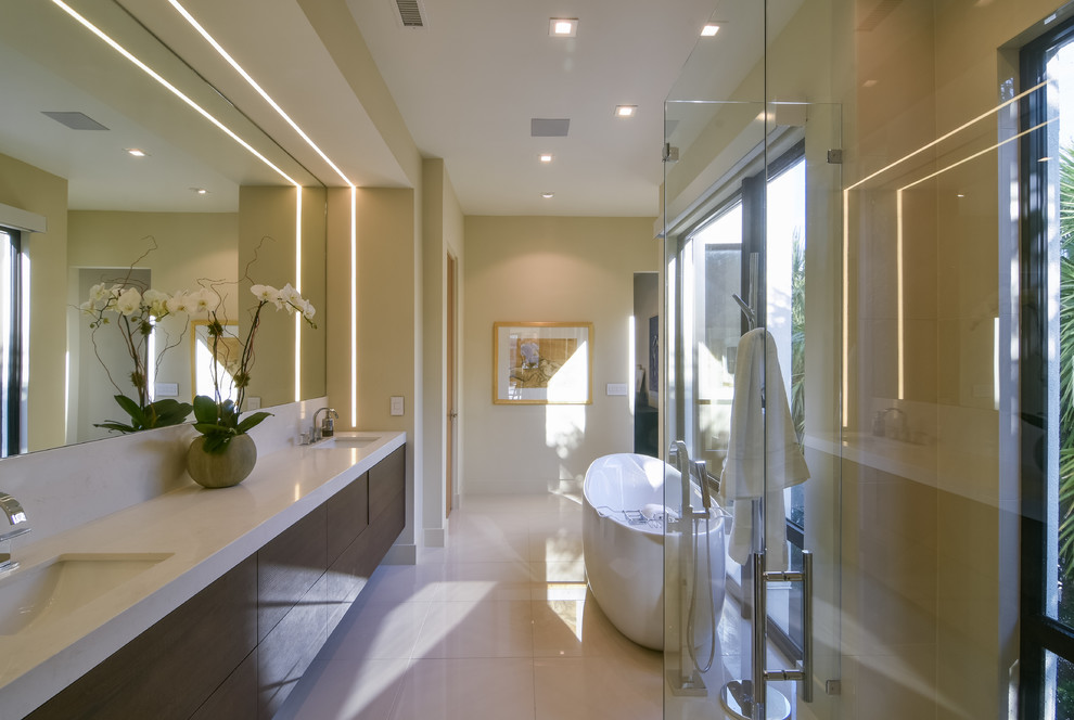Inspiration for a large contemporary master bathroom in Charleston with open cabinets, brown cabinets, a freestanding tub, white tile, porcelain tile, white walls, porcelain floors, a drop-in sink, engineered quartz benchtops, white floor and a hinged shower door.