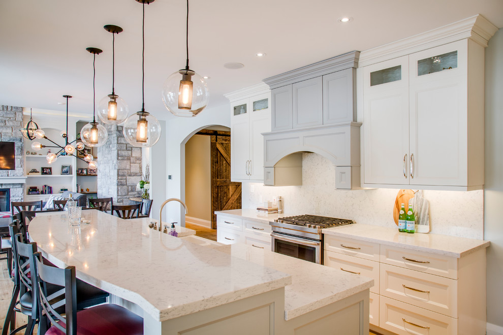 Inspiration for a mid-sized transitional u-shaped light wood floor and brown floor eat-in kitchen remodel with an undermount sink, shaker cabinets, granite countertops, multicolored backsplash, stainless steel appliances, an island and white cabinets