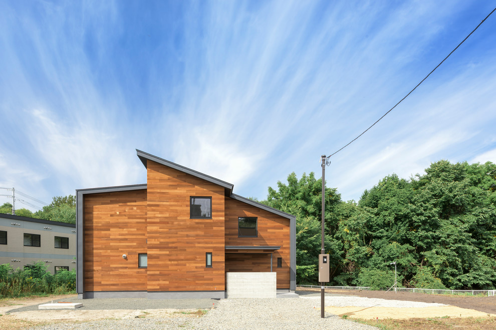 Contemporary brown exterior in Yokohama with wood siding and a shed roof.
