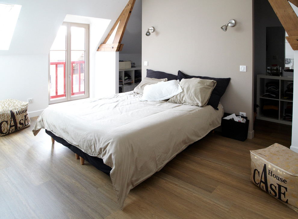 Mid-sized country master bedroom in Lille with beige walls and medium hardwood floors.
