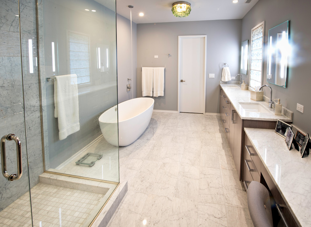 This is an example of a large modern master bathroom in Chicago with flat-panel cabinets, a freestanding tub, a corner shower, gray tile, white tile, marble, grey walls, marble floors, an undermount sink, marble benchtops, white floor and a hinged shower door.
