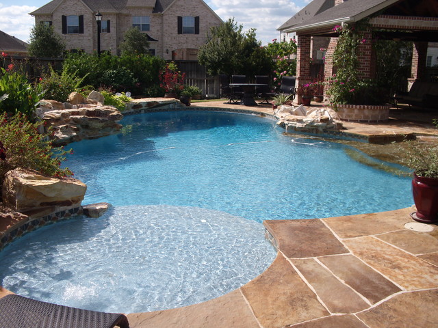 Freeform Pool with waterfalls beach entry sunshelf 