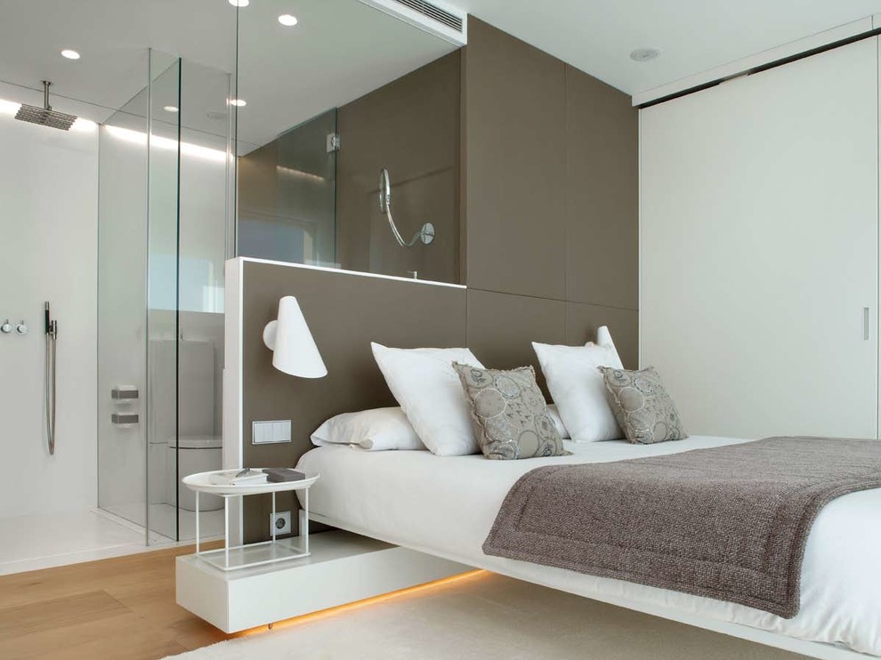 This is an example of a mid-sized contemporary master bedroom in Los Angeles with white walls, light hardwood floors and no fireplace.