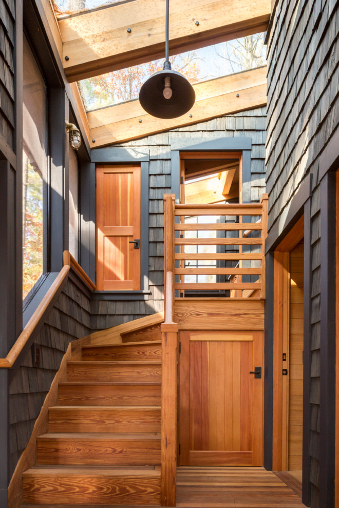 Small mountain style wooden l-shaped wood railing staircase photo in Portland Maine with wooden risers