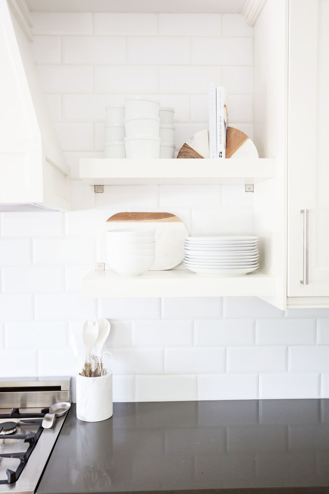 Inspiration for a large transitional u-shaped light wood floor and brown floor eat-in kitchen remodel in Phoenix with a farmhouse sink, recessed-panel cabinets, white cabinets, quartz countertops, white backsplash, subway tile backsplash, stainless steel appliances, an island and white countertops