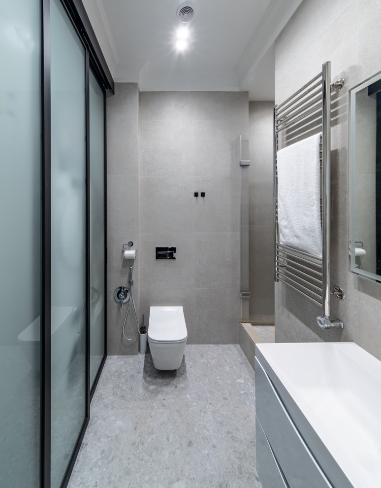 Идея дизайна: ванная комната среднего размера в современном стиле с плоскими фасадами, белыми фасадами, душем в нише, инсталляцией, серой плиткой, керамогранитной плиткой, серыми стенами, полом из керамогранита, душевой кабиной, серым полом, душем с распашными дверями, гигиеническим душем, тумбой под одну раковину и подвесной тумбой
