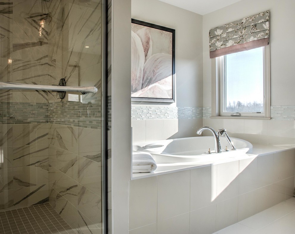 Design ideas for a large transitional master bathroom in Ottawa with recessed-panel cabinets, beige cabinets, a drop-in tub, an alcove shower, a two-piece toilet, porcelain tile, beige walls, ceramic floors, a drop-in sink, marble benchtops, beige tile and grey floor.