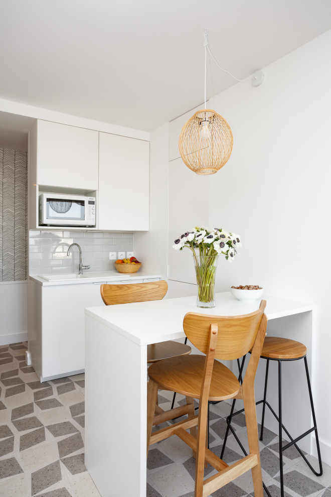 Idéer för att renovera ett mellanstort minimalistiskt vit vitt kök, med en enkel diskho, släta luckor, vita skåp, laminatbänkskiva, grått stänkskydd, stänkskydd i keramik, integrerade vitvaror, klinkergolv i keramik och grått golv