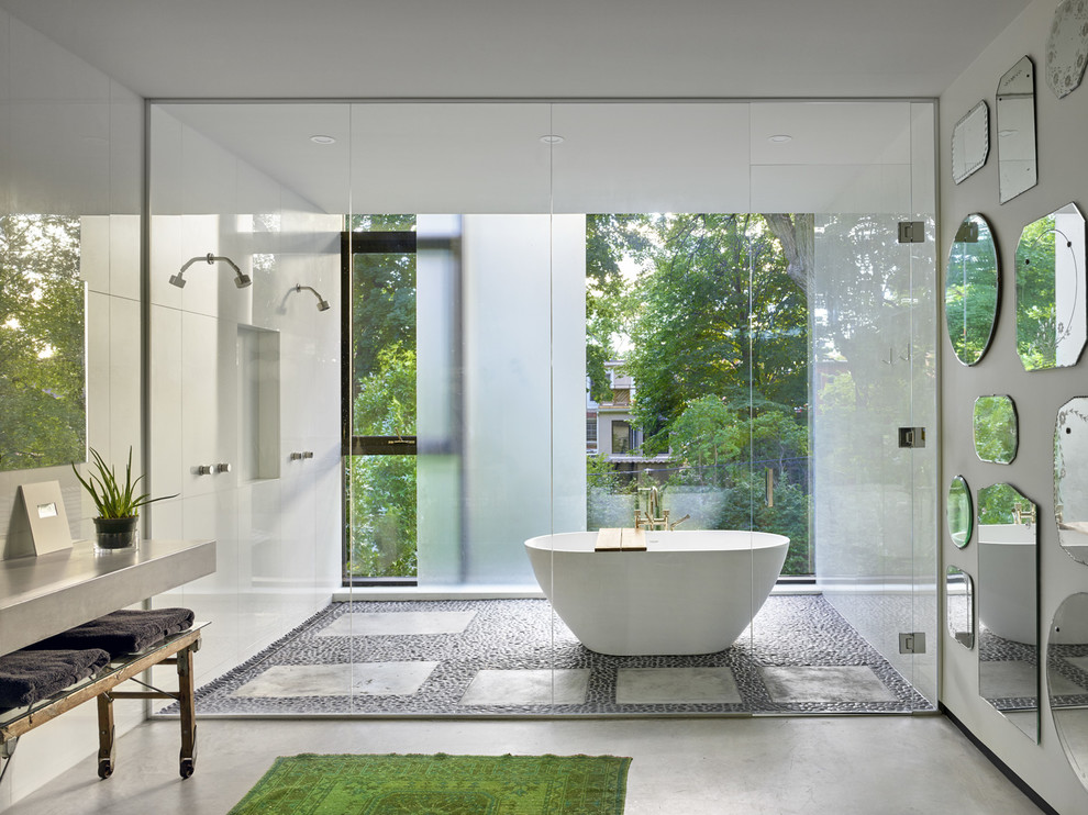 This is an example of a modern master bathroom in Toronto with a freestanding tub, an open shower, white walls, grey floor and a hinged shower door.