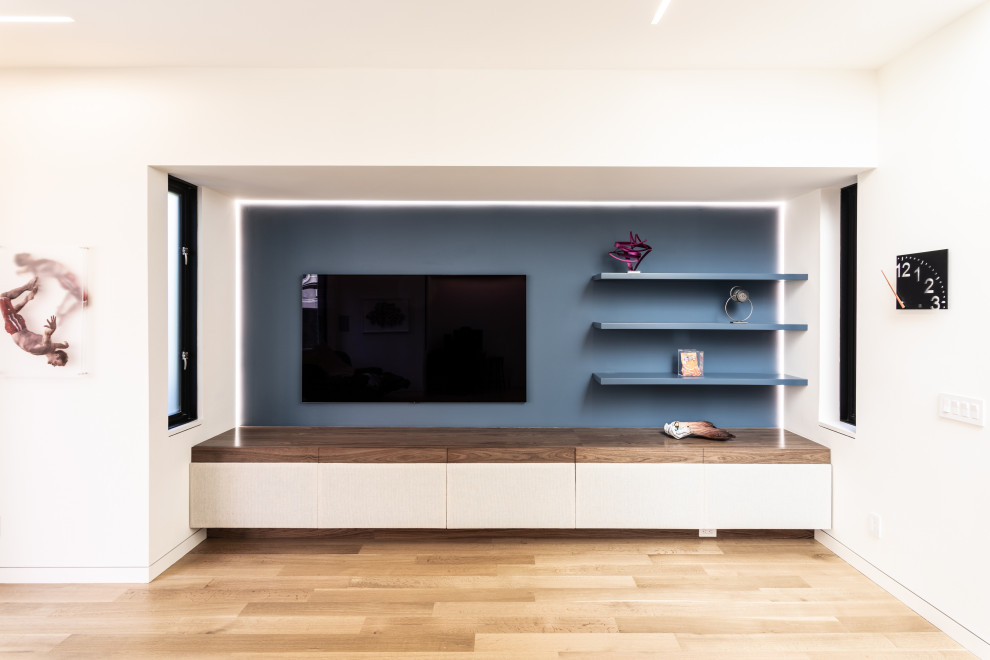 Idee per un soggiorno moderno di medie dimensioni e aperto con pareti blu, parquet chiaro, parete attrezzata e pavimento marrone