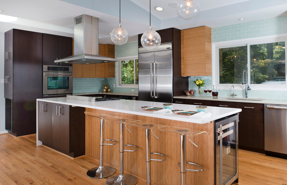Contemporary l-shaped kitchen in DC Metro with an undermount sink, flat-panel cabinets, dark wood cabinets, blue splashback, glass tile splashback, stainless steel appliances, medium hardwood floors and with island.