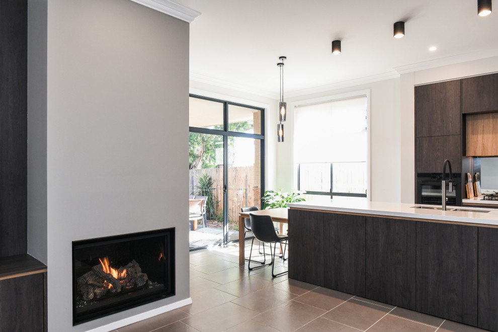 Design ideas for a mid-sized contemporary open concept living room in Sydney with black walls, ceramic floors, a standard fireplace, a plaster fireplace surround and a freestanding tv.