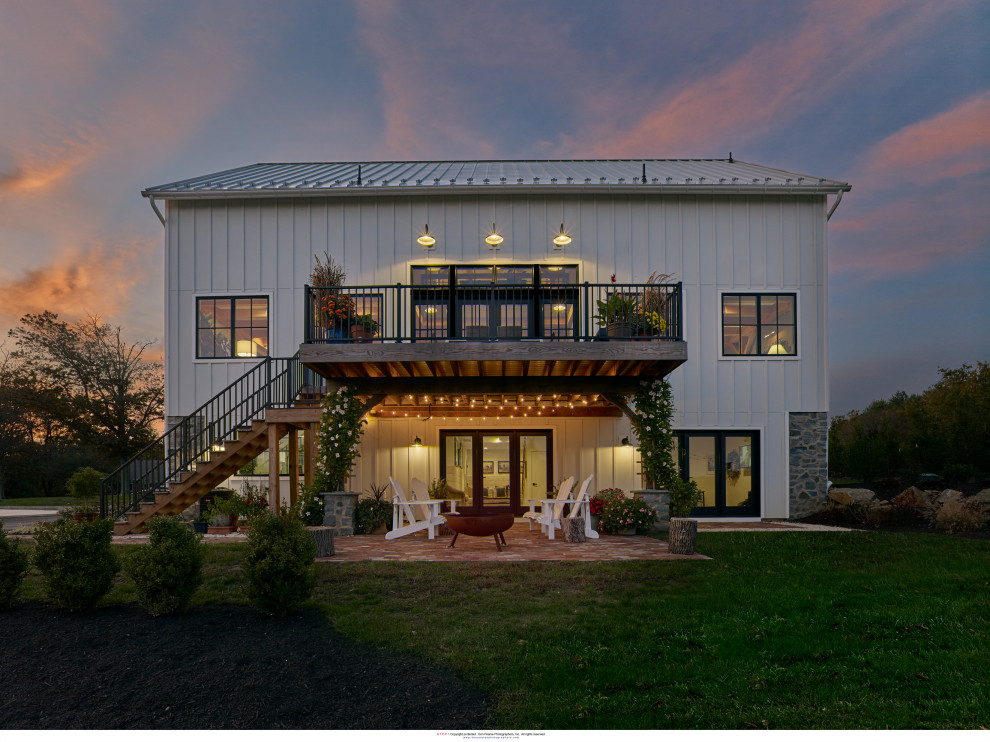 Foto de fachada de casa blanca y gris clásica renovada de tamaño medio de dos plantas con revestimiento de hormigón, tejado a dos aguas, tejado de metal y panel y listón