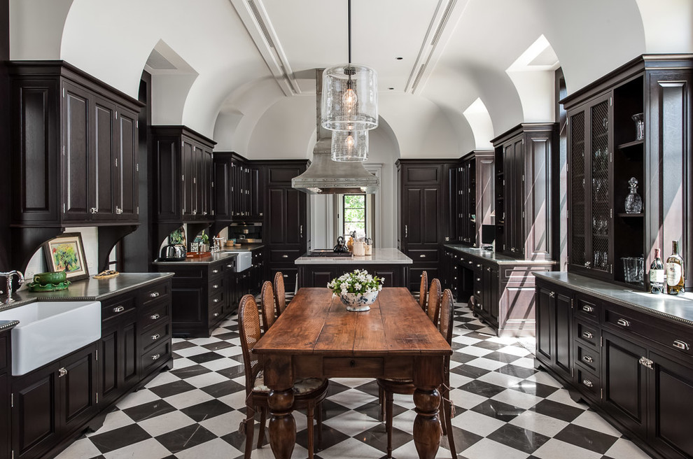 Inspiration for a traditional u-shaped eat-in kitchen in Miami with a farmhouse sink, raised-panel cabinets, dark wood cabinets and multi-coloured floor.