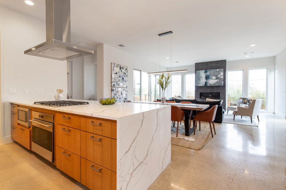 Inspiration for a mid-sized midcentury galley open plan kitchen in Austin with an undermount sink, shaker cabinets, medium wood cabinets, quartzite benchtops, white splashback, stone slab splashback, stainless steel appliances, concrete floors, no island, beige floor and white benchtop.