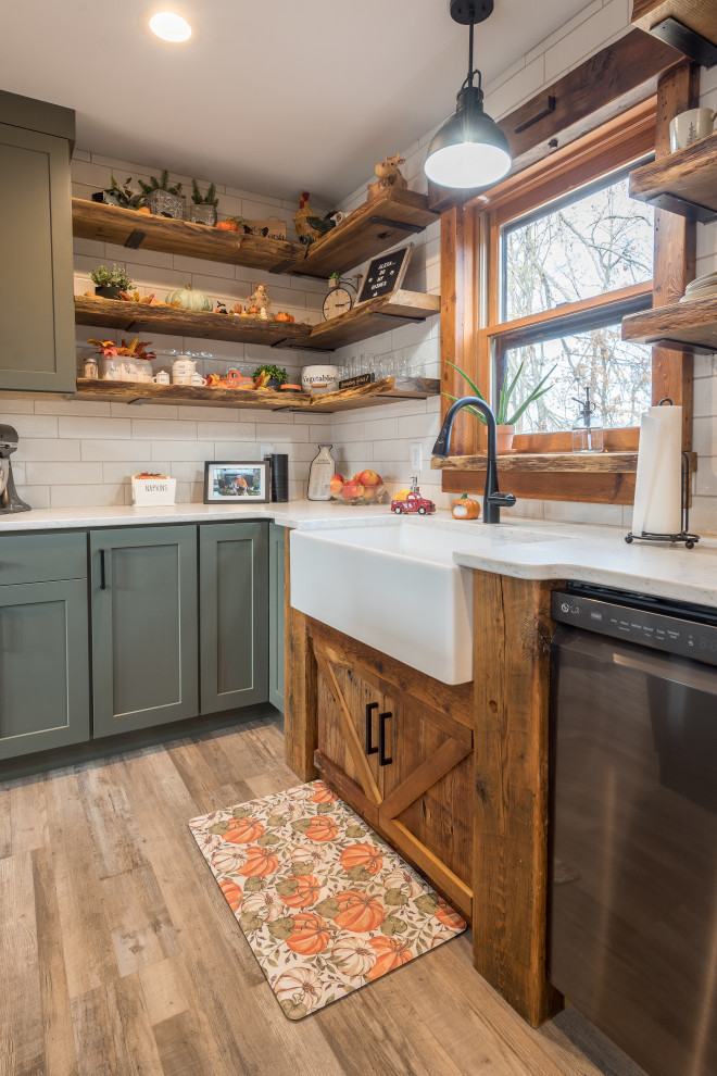 This is an example of a large transitional l-shaped eat-in kitchen in Minneapolis with a farmhouse sink, shaker cabinets, green cabinets, wood benchtops, white splashback, ceramic splashback, vinyl floors, with island, beige floor and brown benchtop.