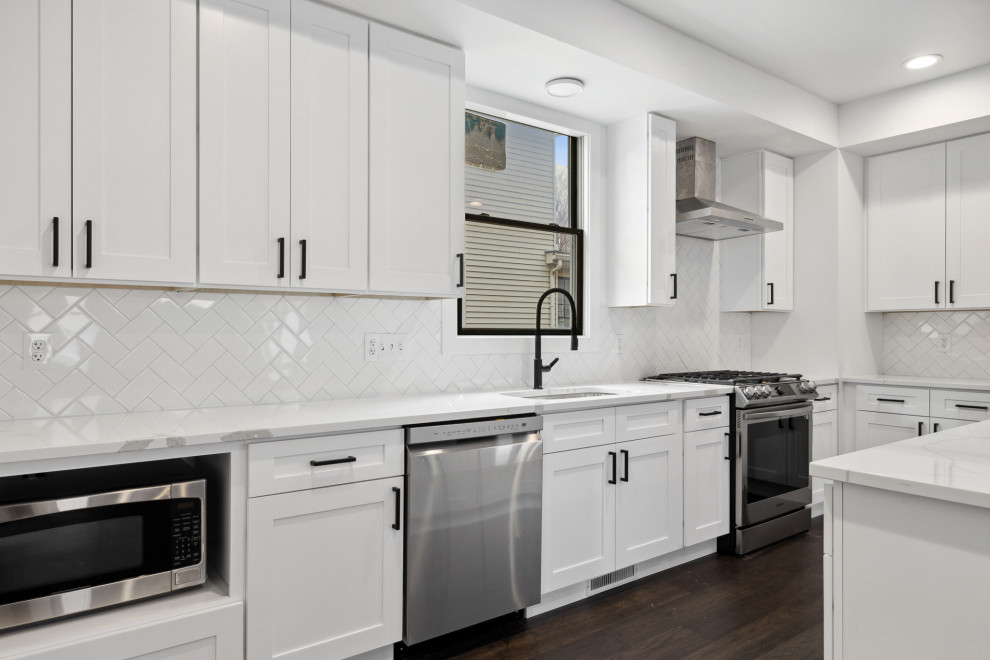 Example of a large transitional u-shaped dark wood floor and brown floor eat-in kitchen design in Minneapolis with a single-bowl sink, shaker cabinets, white cabinets, quartz countertops, white backsplash, ceramic backsplash, stainless steel appliances, an island and white countertops